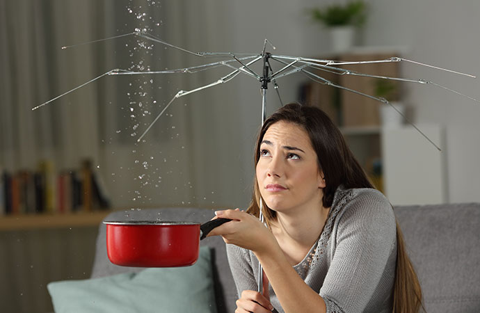 Woman Holding Pot To Catch Water