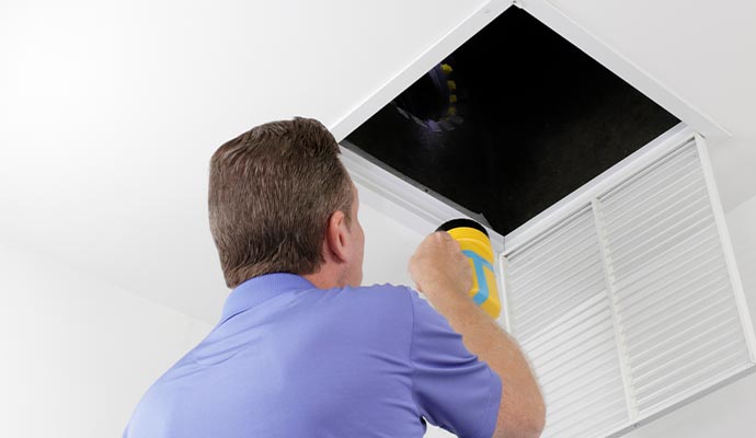 Person inspecting a duct system