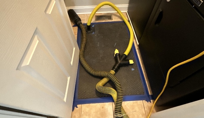 A professional floor-drying mat system with yellow vacuum hoses
