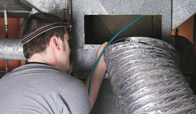 Person cleaning duct