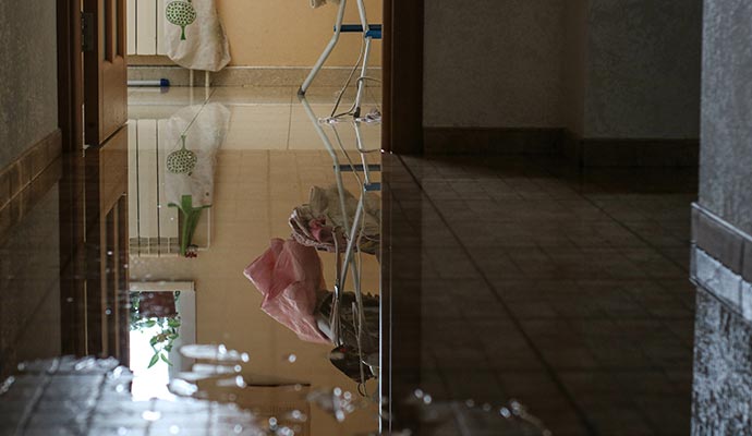 Room with tile flooring damaged by a plumbing leak.