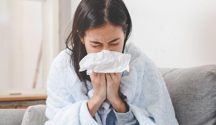 A person experiencing allergy issues in a room due to sewage