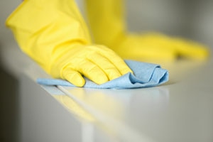 person sanitizing surfaces