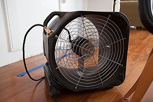 a fan being used to dry water and prevent the development of mold